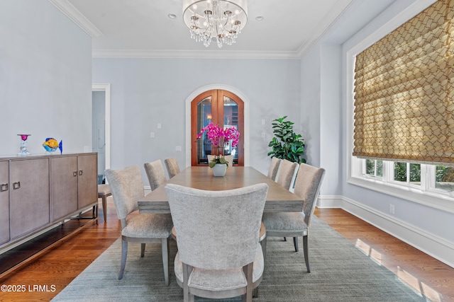 dining space with crown molding, dark hardwood / wood-style floors, and a chandelier