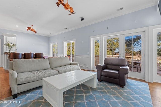 living room featuring hardwood / wood-style floors, ornamental molding, and french doors