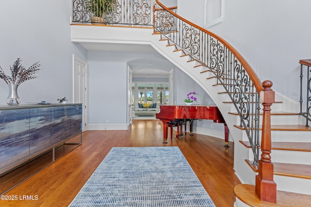 entrance foyer featuring hardwood / wood-style floors and a towering ceiling