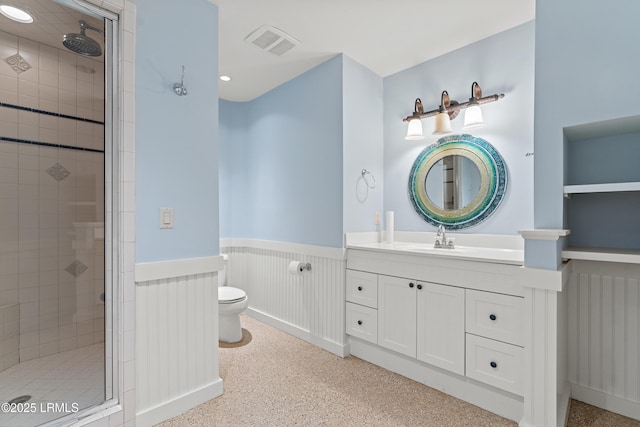 bathroom with vanity, toilet, and a shower with door