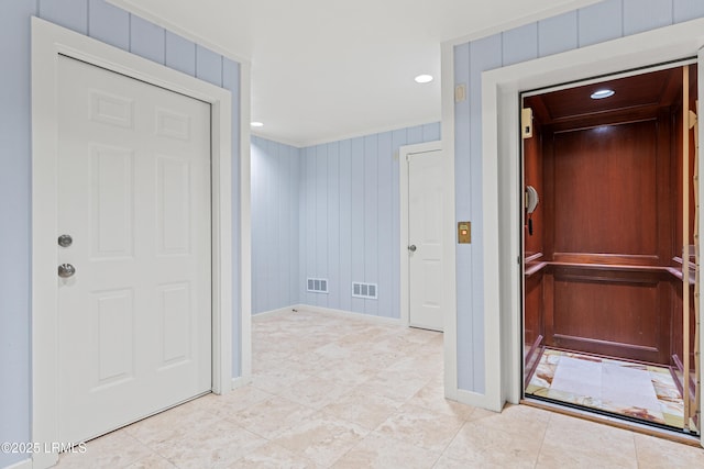 corridor featuring light tile patterned flooring and wood walls