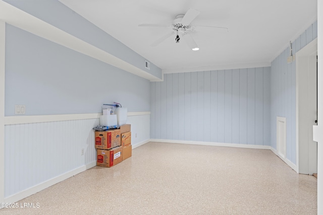 bonus room featuring wooden walls and ceiling fan