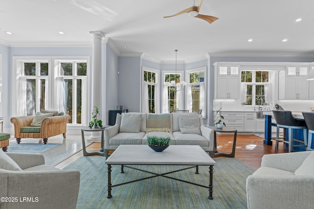 living room featuring crown molding, wood-type flooring, and a healthy amount of sunlight