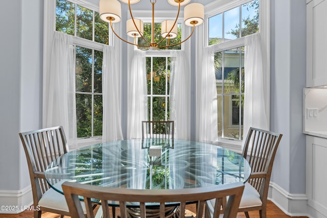 dining area with hardwood / wood-style flooring and an inviting chandelier