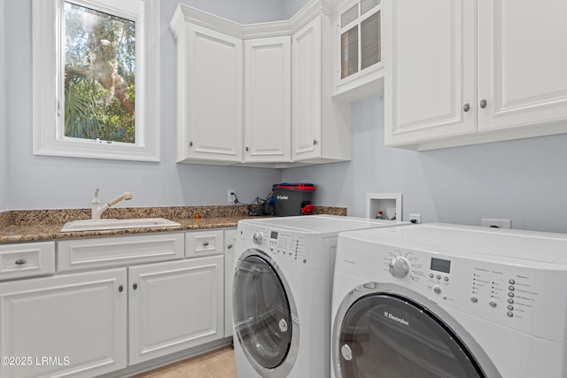 laundry area with separate washer and dryer, sink, and cabinets