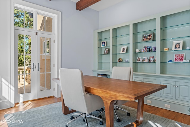 office space featuring beam ceiling, light hardwood / wood-style floors, and french doors