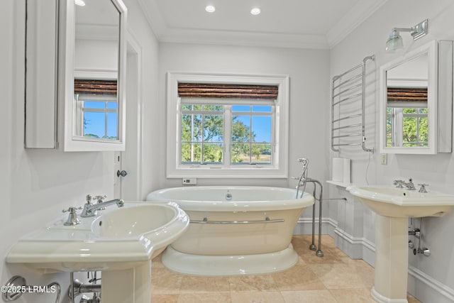 bathroom with tile patterned flooring, a tub to relax in, crown molding, and double sink