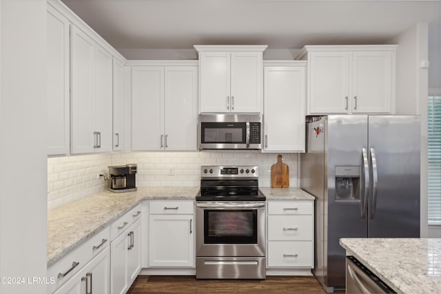 kitchen featuring white cabinetry, light stone counters, decorative backsplash, and stainless steel appliances