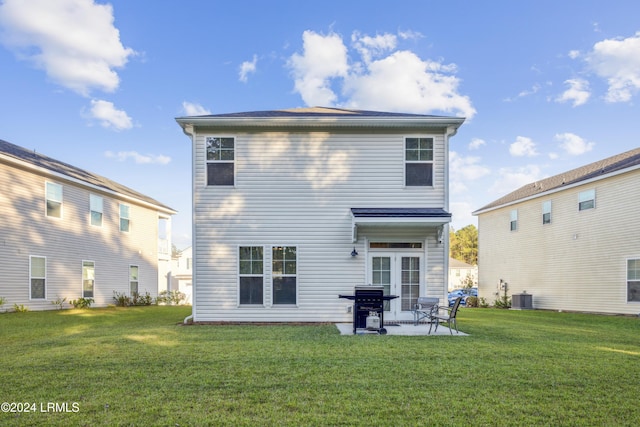 rear view of house featuring cooling unit, a yard, a patio area, and french doors