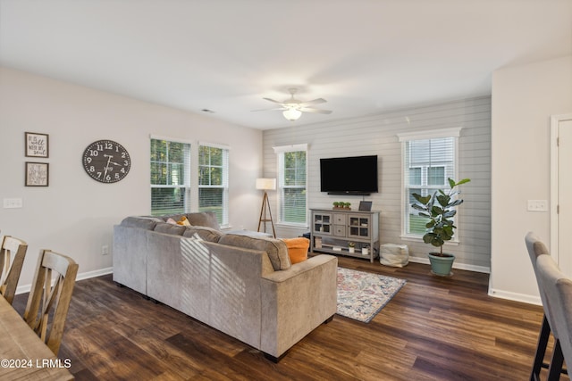 living room featuring dark wood-type flooring, ceiling fan, and a healthy amount of sunlight