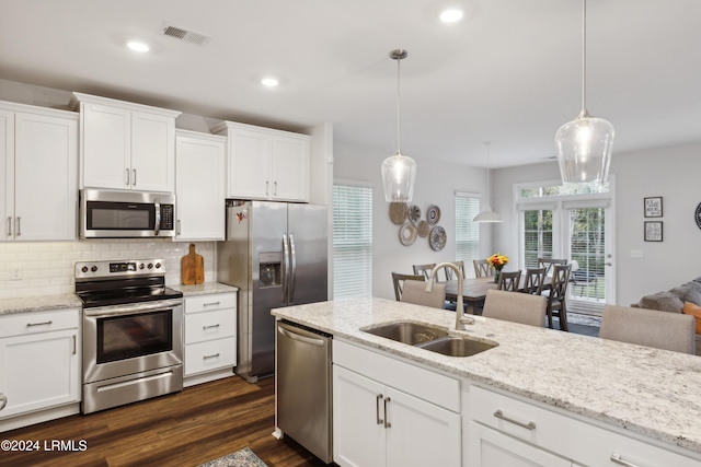 kitchen with pendant lighting, white cabinetry, stainless steel appliances, and sink