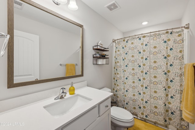 bathroom featuring vanity, walk in shower, and toilet