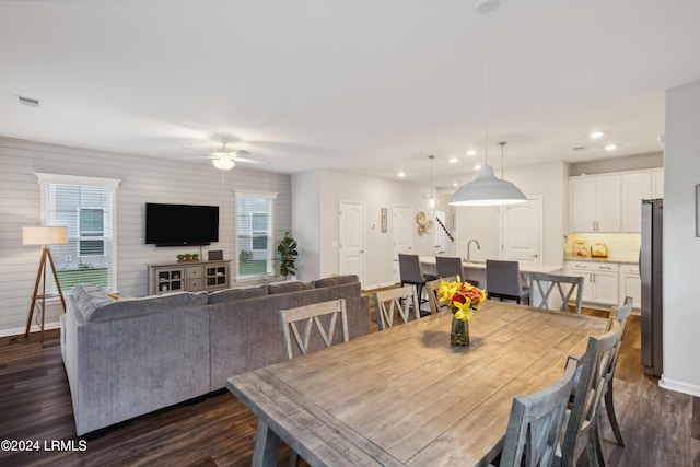 dining area featuring sink, dark wood-type flooring, and a healthy amount of sunlight