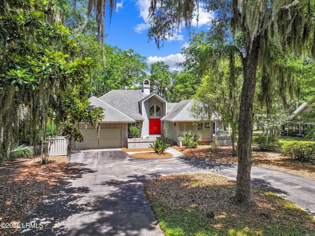 647 Island Cir E, Saint Helena Island, SC 29920 - obstructed view of property with driveway, a garage, a shingled roof, and a chimney