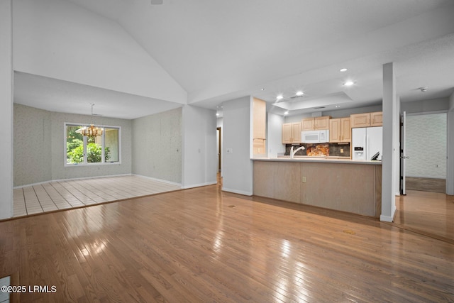 647 Island Cir E, Saint Helena Island, SC 29920 - unfurnished living room featuring light wood-type flooring, a chandelier, vaulted ceiling, baseboards, and recessed lighting