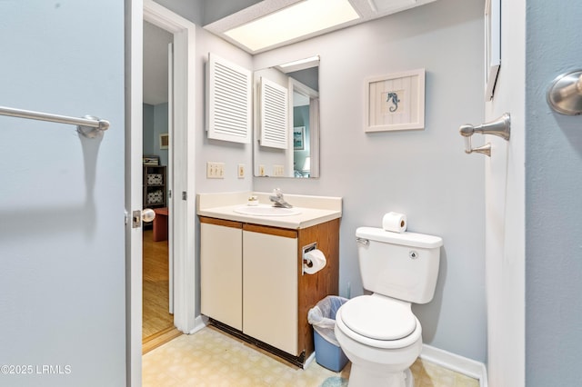 bathroom featuring toilet, vanity, baseboards, and tile patterned floors