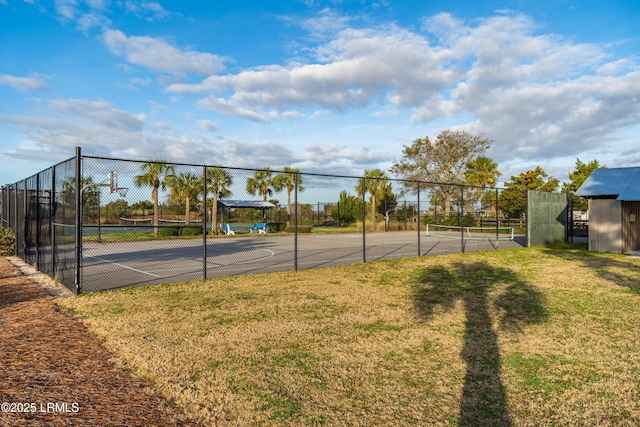 view of sport court featuring fence and a yard