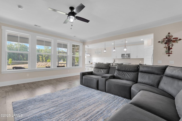 living room with a ceiling fan, wood finished floors, and baseboards