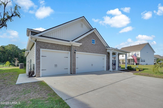 view of front of property featuring board and batten siding, brick siding, a garage, driveway, and a front yard