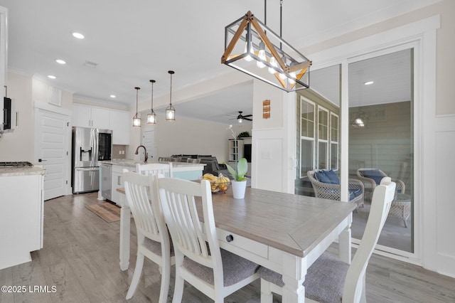 dining area featuring light wood-type flooring, a ceiling fan, ornamental molding, and recessed lighting