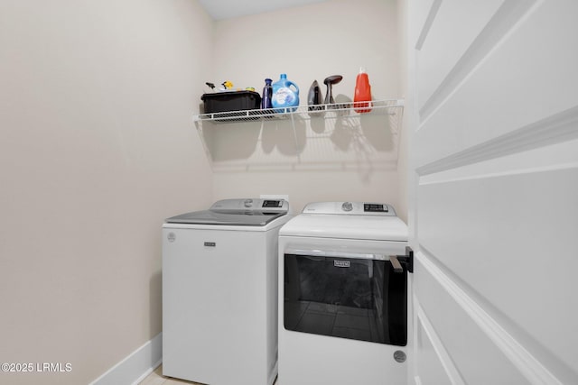 laundry area with washing machine and clothes dryer, laundry area, and baseboards