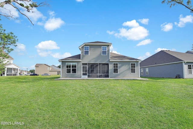 back of house with roof with shingles, a sunroom, and a lawn