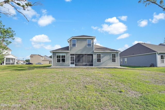back of house featuring a shingled roof, a sunroom, and a lawn