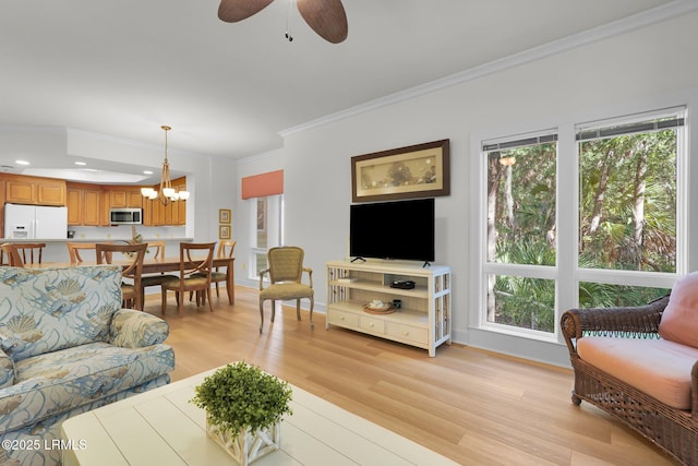 living room with ornamental molding, ceiling fan with notable chandelier, and light hardwood / wood-style floors