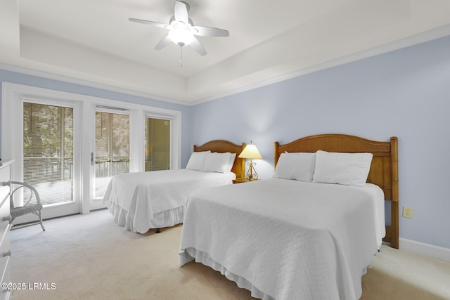 carpeted bedroom featuring a raised ceiling, access to exterior, and ceiling fan