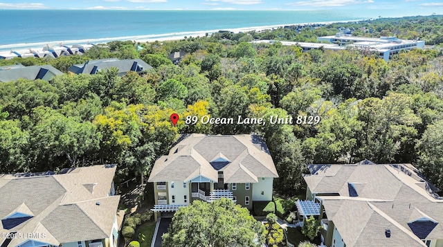 birds eye view of property with a water view and a beach view