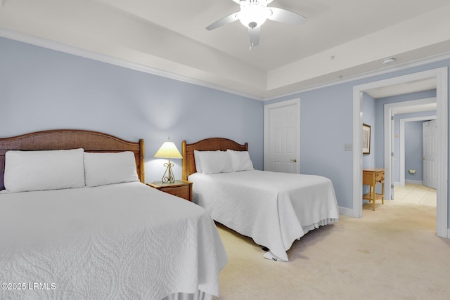 bedroom with ceiling fan, a raised ceiling, and light colored carpet