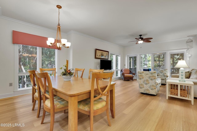 dining space with ceiling fan with notable chandelier, ornamental molding, and light hardwood / wood-style floors