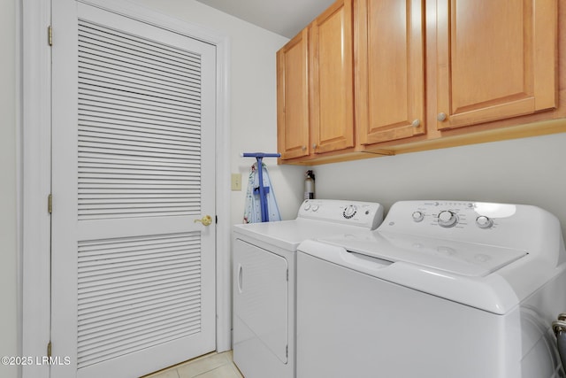 laundry area with cabinets, light tile patterned floors, and independent washer and dryer