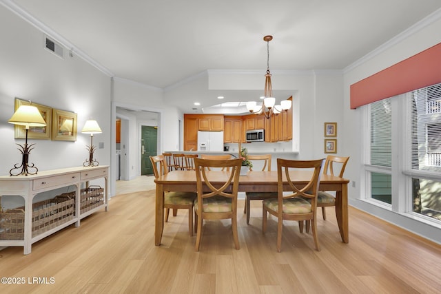 dining room featuring a notable chandelier, light hardwood / wood-style flooring, and ornamental molding