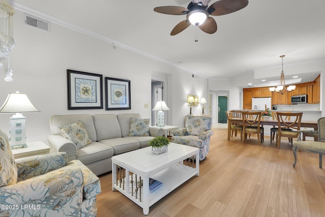 living room featuring crown molding, ceiling fan with notable chandelier, and light wood-type flooring