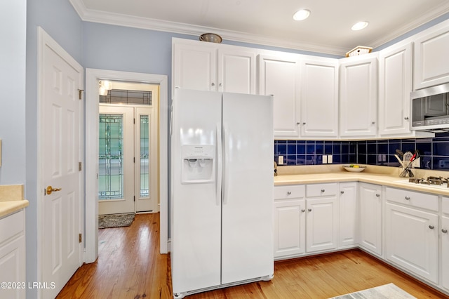 kitchen with light wood-style flooring, white appliances, white cabinets, decorative backsplash, and crown molding