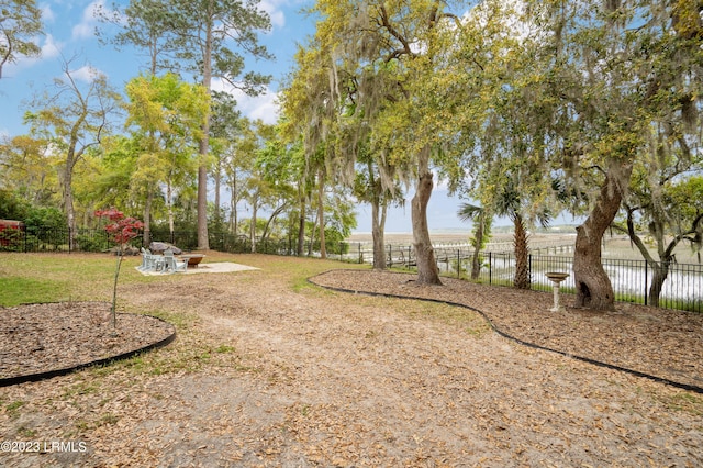 view of yard featuring fence, a fire pit, and a patio