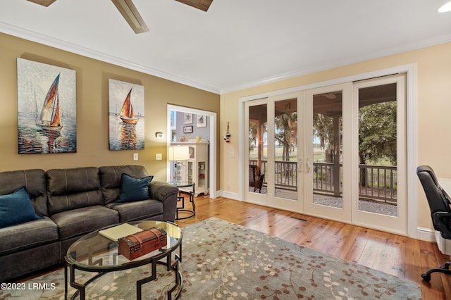 living room with baseboards, a ceiling fan, hardwood / wood-style flooring, ornamental molding, and french doors