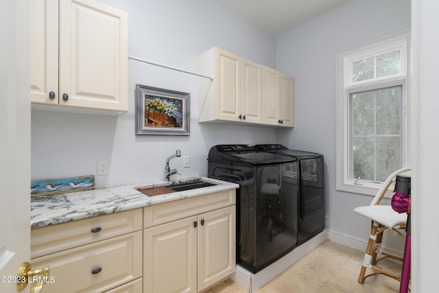 laundry room featuring cabinets, separate washer and dryer, and sink