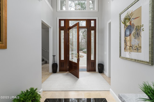 tiled entrance foyer featuring a towering ceiling