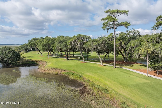 surrounding community with a water view and a lawn