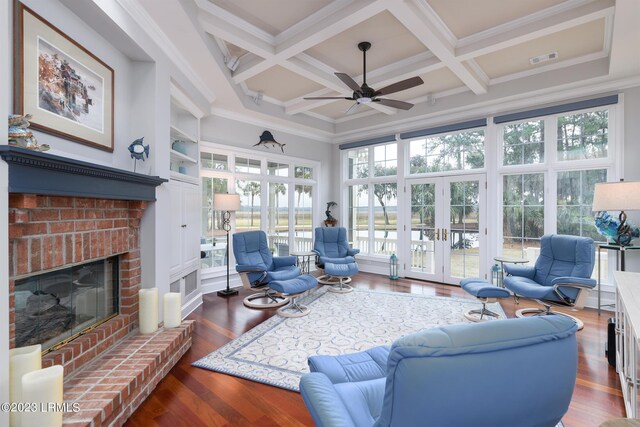 living room with french doors, coffered ceiling, a brick fireplace, ornamental molding, and dark hardwood / wood-style floors