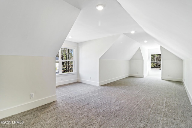 additional living space with lofted ceiling and light carpet