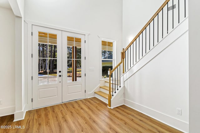 foyer entrance with french doors and wood-type flooring