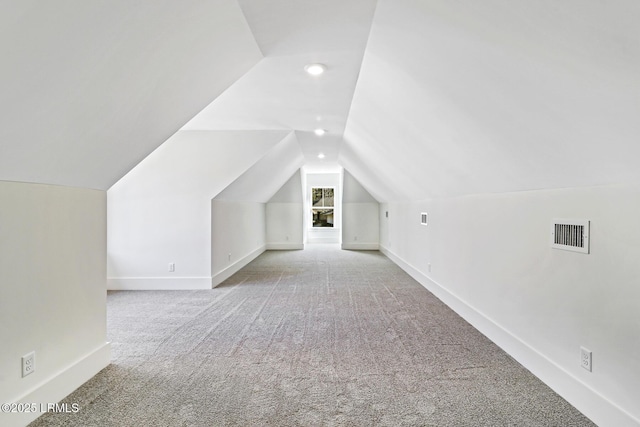 bonus room featuring lofted ceiling and light carpet