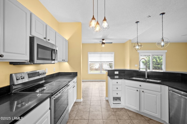 6 Broadland Cir, Bluffton, SC 29910 - kitchen with stainless steel appliances, a sink, dark countertops, a ceiling fan, and a textured ceiling