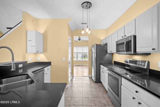 6 Broadland Cir, Bluffton, SC 29910 - kitchen featuring stainless steel appliances, dark countertops, a sink, lofted ceiling, and white cabinetry