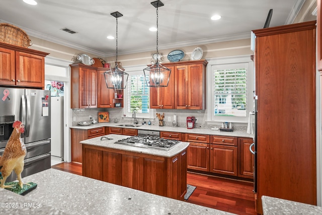 120 Coosaw Club Dr, Beaufort, SC 29907 - kitchen with appliances with stainless steel finishes, a sink, dark wood-style flooring, brown cabinetry, and crown molding