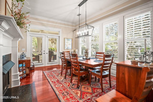 120 Coosaw Club Dr, Beaufort, SC 29907 - dining area with a fireplace, wood finished floors, crown molding, a chandelier, and french doors