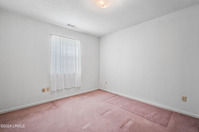 carpeted spare room featuring a textured ceiling